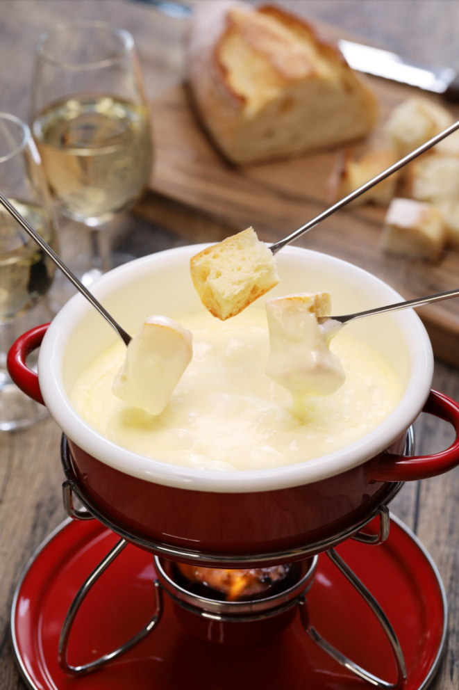 red swiss cheese fondue set with 3 pieces of bread